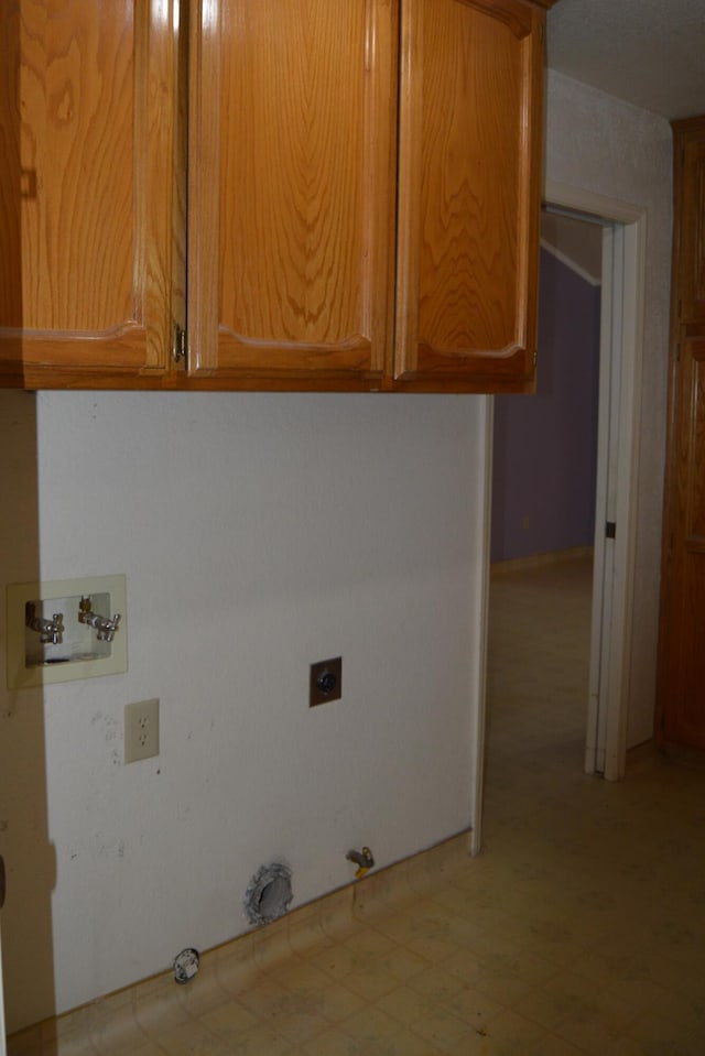 washroom with washer hookup, light floors, hookup for an electric dryer, cabinet space, and gas dryer hookup