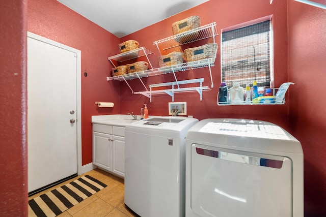 laundry area featuring cabinet space, independent washer and dryer, a sink, and light tile patterned floors