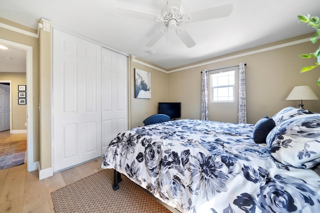 bedroom with a closet, crown molding, and light wood-style flooring