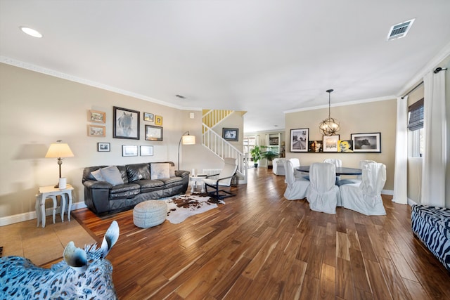 living room with ornamental molding, visible vents, stairway, and wood finished floors