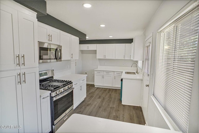 1109 W W Ave Unit J8, Lancaster, CA 93534 - kitchen featuring appliances with stainless steel finishes, white cabinets, wood finished floors, recessed lighting, and light countertops