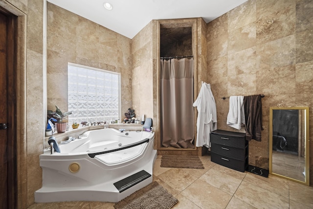 bathroom featuring tile patterned floors, a bathtub, and tile walls