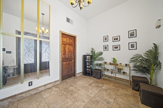 tiled entrance foyer with a notable chandelier