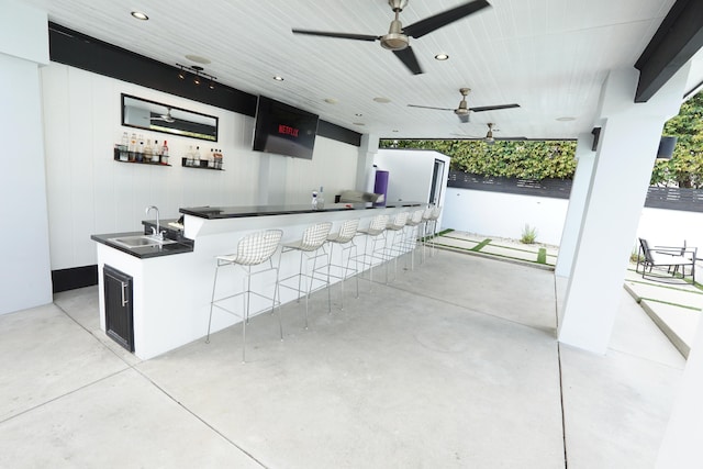 view of patio featuring a ceiling fan, outdoor wet bar, and a sink