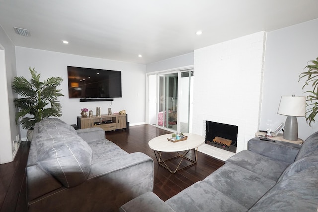 living room featuring a fireplace, wood finished floors, visible vents, and recessed lighting