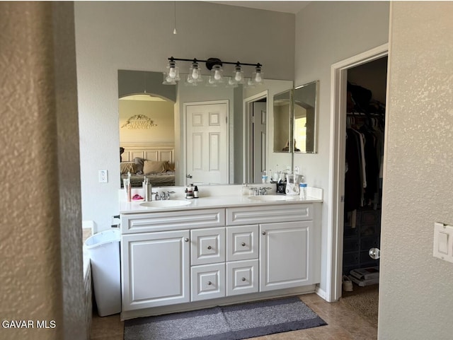 3309 W Brabham Ave, Rosamond, CA 93560 - ensuite bathroom featuring double vanity, tile patterned flooring, and a walk in closet