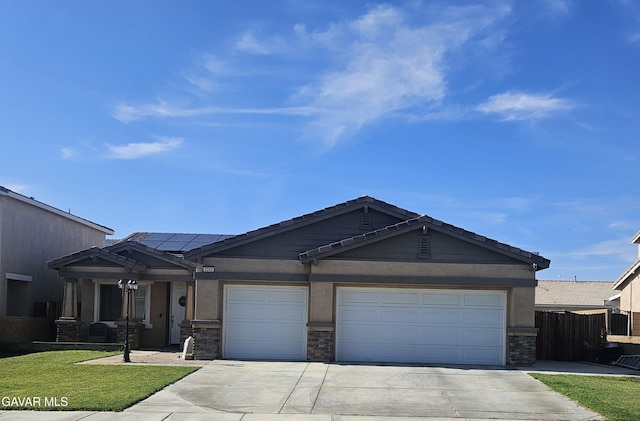 3309 W Brabham Ave, Rosamond, CA 93560 - view of front facade with driveway, solar panels, stone siding, and an attached garage