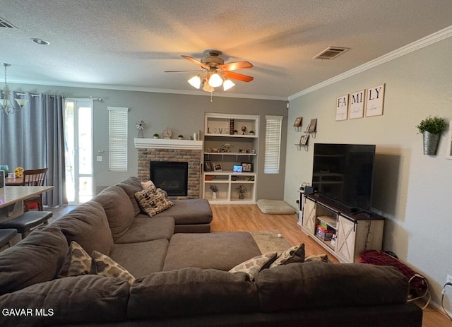 3309 W Brabham Ave, Rosamond, CA 93560 - living room with light wood-type flooring, ornamental molding, ceiling fan, a fireplace, and a textured ceiling