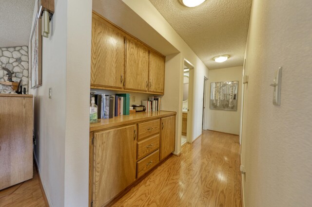 29948 Greenwater Dr, Tehachapi, CA 93561 - corridor with a textured ceiling and light wood-type flooring