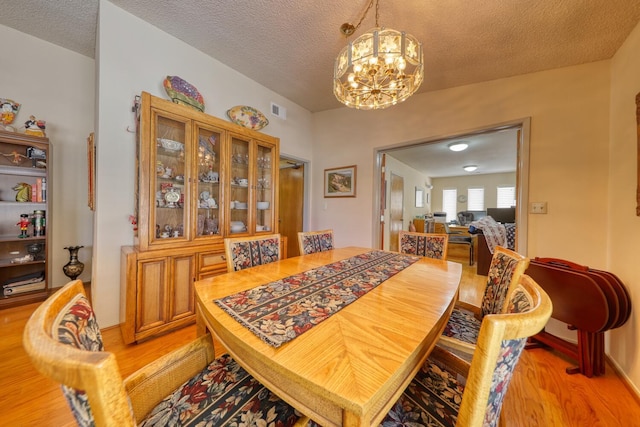 29948 Greenwater Dr, Tehachapi, CA 93561 - dining space with a chandelier, light wood finished floors, and a textured ceiling