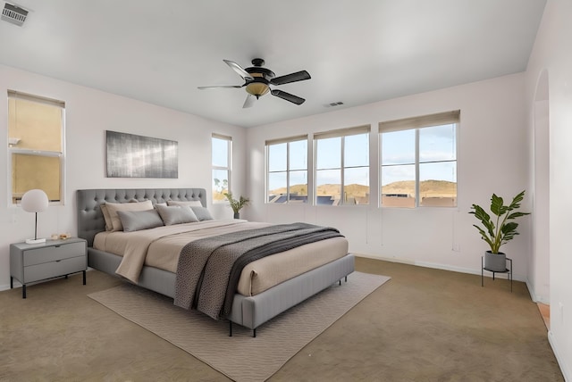 carpeted bedroom featuring multiple windows, visible vents, and arched walkways