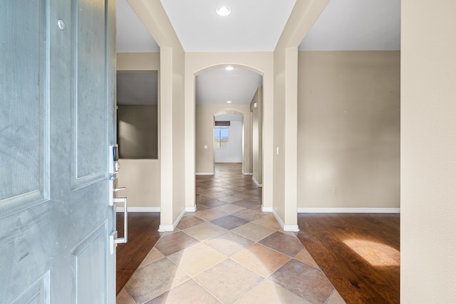 foyer entrance with arched walkways, wood finished floors, baseboards, and recessed lighting