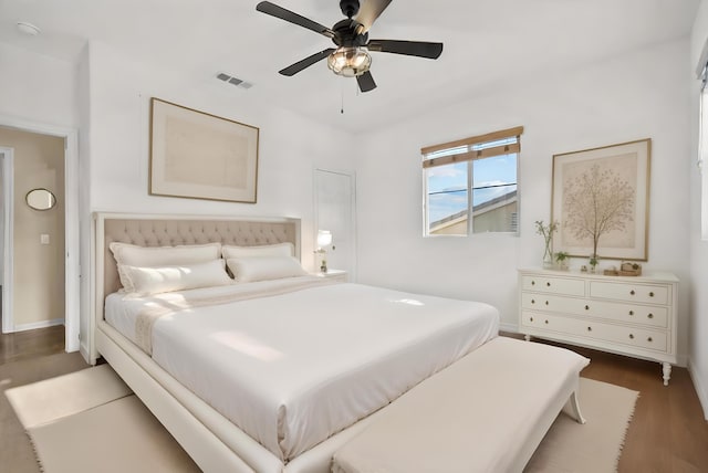 bedroom featuring baseboards, visible vents, ceiling fan, and wood finished floors