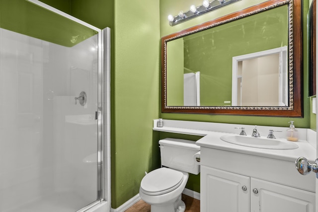 full bathroom with toilet, a shower stall, vanity, and baseboards