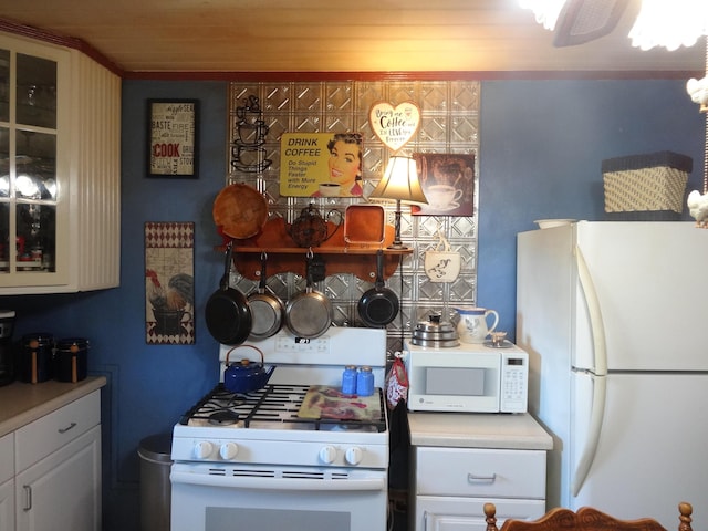 kitchen featuring white cabinets and white appliances