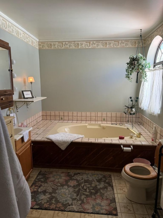 bathroom with vanity, a relaxing tiled tub, and toilet