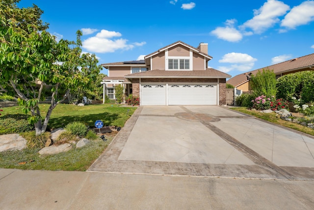 28314 Easton Ln, Saugus, CA 91350 - traditional-style home featuring an attached garage, a chimney, brick siding, roof mounted solar panels, and a front yard