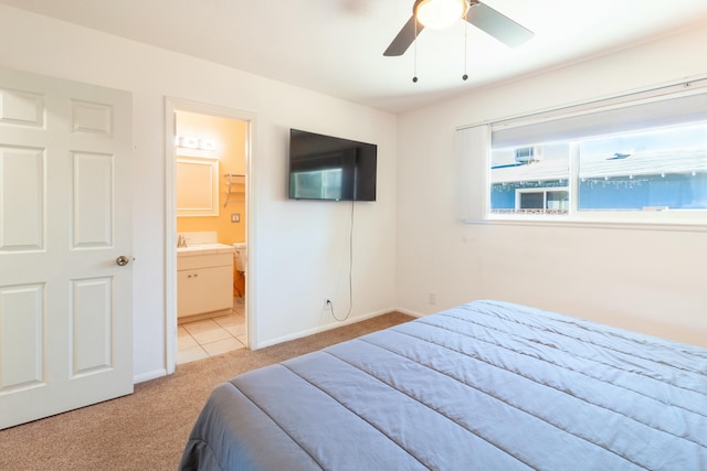 bedroom with ensuite bathroom, sink, ceiling fan, and light colored carpet