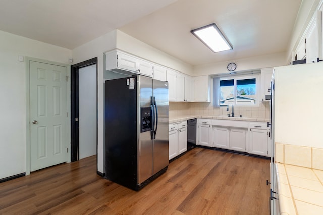 kitchen with stainless steel refrigerator with ice dispenser, sink, dishwasher, light hardwood / wood-style floors, and white cabinetry