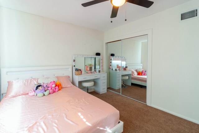 bedroom with ceiling fan, a closet, and dark colored carpet