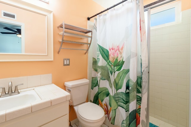 bathroom featuring vanity, toilet, curtained shower, and ceiling fan