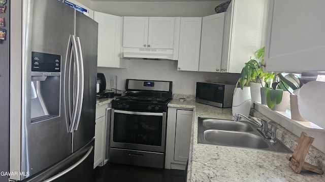 2325 E Pecos Ct, Lancaster, CA 93535 - kitchen featuring appliances with stainless steel finishes, under cabinet range hood, light countertops, and white cabinetry