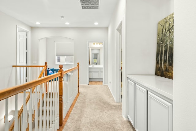 corridor featuring light colored carpet