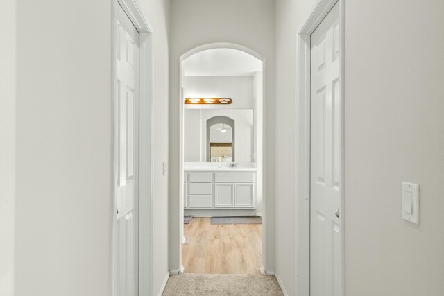 hallway featuring light colored carpet