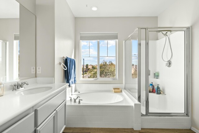 bathroom with vanity and shower with separate bathtub