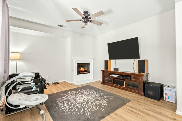 living room featuring light hardwood / wood-style flooring and ceiling fan