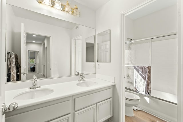 full bathroom featuring hardwood / wood-style flooring, vanity, shower / bathtub combination, and toilet