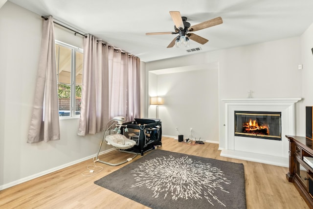 living area with light hardwood / wood-style flooring and ceiling fan