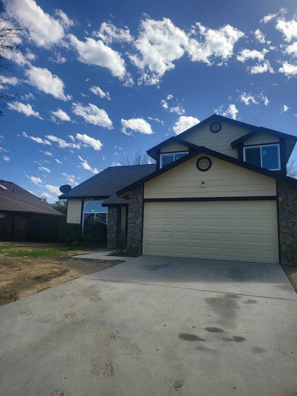 view of front of home featuring driveway, stone siding, and an attached garage