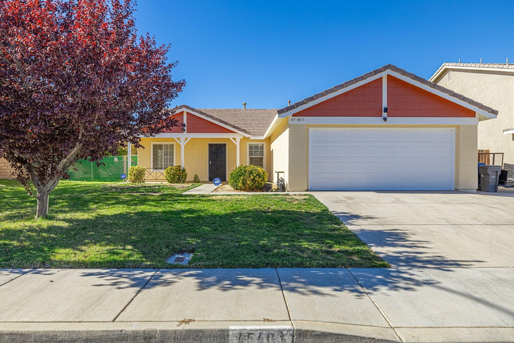 ranch-style house with a garage and a front lawn