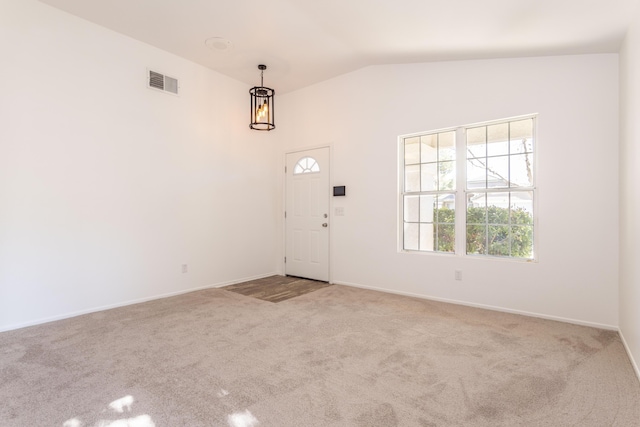 carpeted foyer entrance with vaulted ceiling