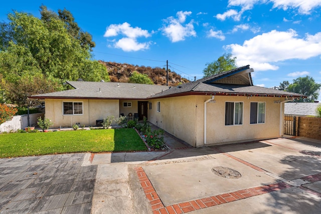 view of front of house featuring a patio area and a front lawn