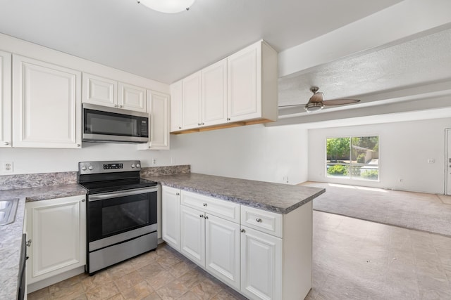 2823 W W Ave Unit J4, Lancaster, CA 93536 - kitchen featuring stainless steel appliances, a ceiling fan, open floor plan, a peninsula, and white cabinetry