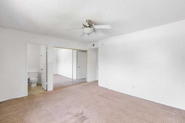 2823 W W Ave Unit J4, Lancaster, CA 93536 - unfurnished bedroom with carpet flooring, a closet, connected bathroom, a textured ceiling, and ceiling fan