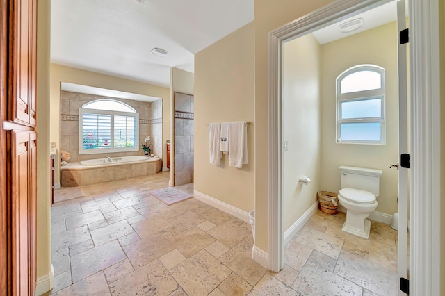 3719 Camino Hermanos, Lancaster, CA 93536 - bathroom with stone tile floors, a garden tub, toilet, and baseboards