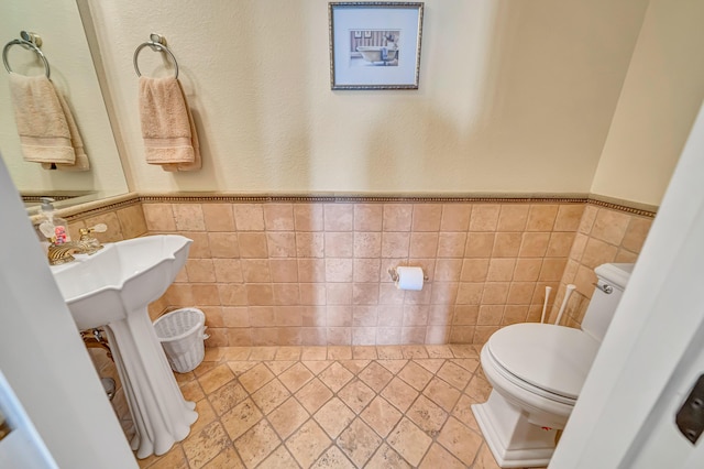3719 Camino Hermanos, Lancaster, CA 93536 - bathroom with toilet, tile walls, and wainscoting