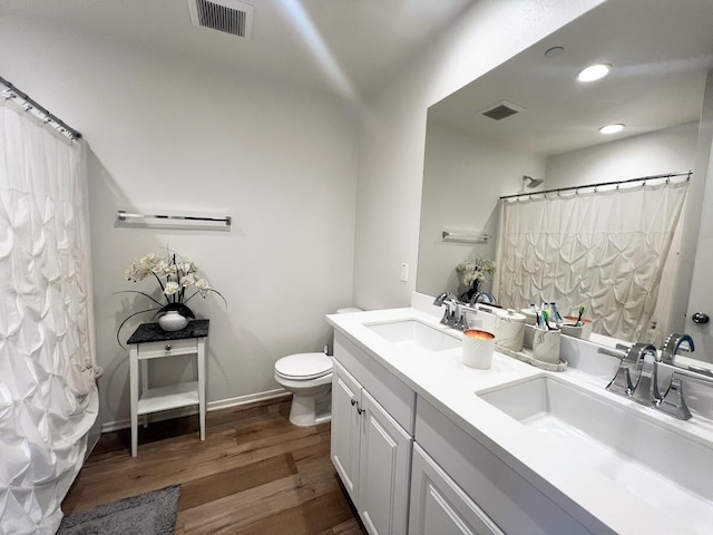 bathroom with a shower with curtain, hardwood / wood-style floors, vanity, and toilet