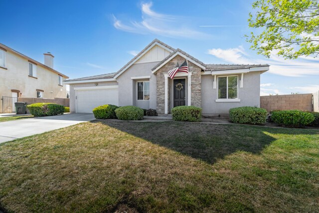 ranch-style home with a front yard, fence, a garage, stucco siding, and stone siding