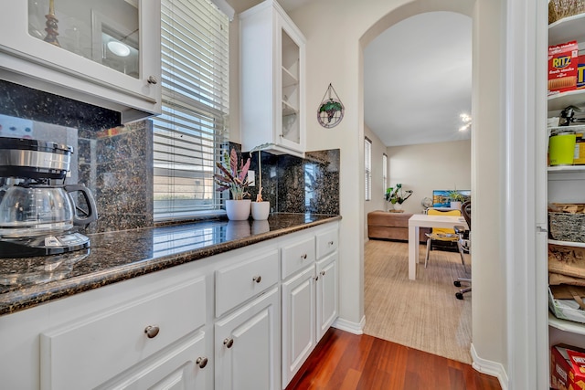 kitchen with white cabinets, tasteful backsplash, glass insert cabinets, and dark wood-type flooring