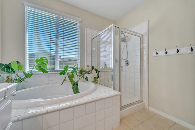full bathroom with a garden tub, baseboards, tile patterned flooring, and a shower stall
