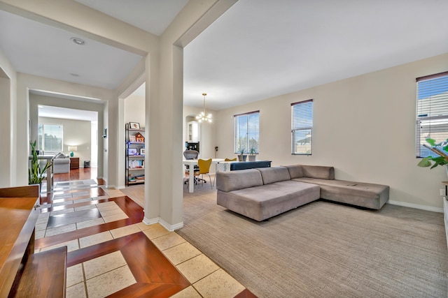 living room with a notable chandelier, baseboards, and light tile patterned floors