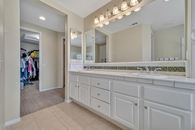 bathroom with backsplash, baseboards, double vanity, and a sink