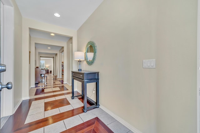hallway with recessed lighting, baseboards, and tile patterned floors
