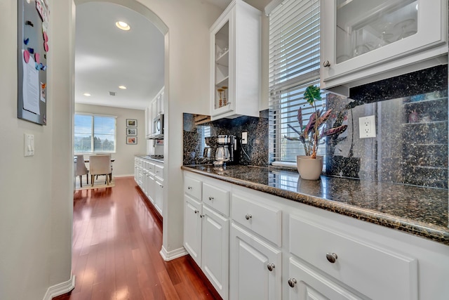interior space with stainless steel microwave, tasteful backsplash, dark wood-type flooring, recessed lighting, and baseboards