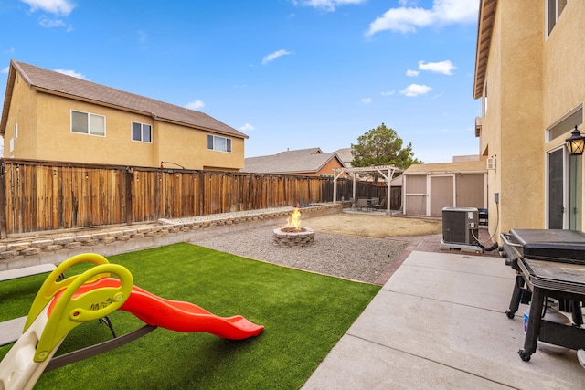 view of yard with an outdoor fire pit, cooling unit, a fenced backyard, an outdoor structure, and a patio