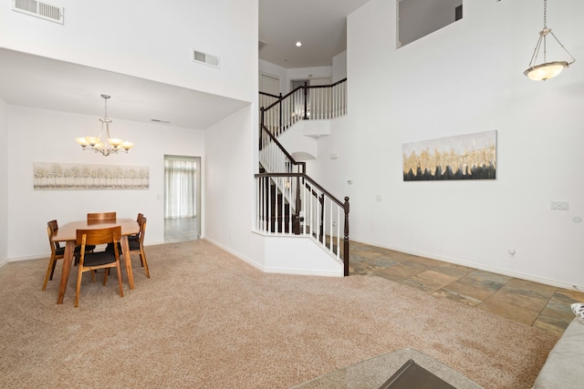 carpeted dining area with an inviting chandelier, stairway, baseboards, and visible vents